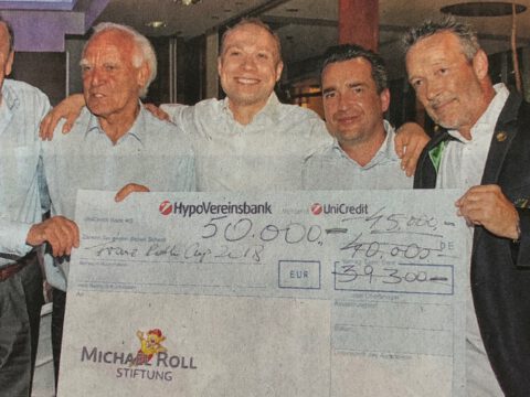 Fünf Männer präsentieren bei Charity-Gala einen Riesenscheck; Spendenübergabe mit HypoVereinsbank/UniCredit-Logo